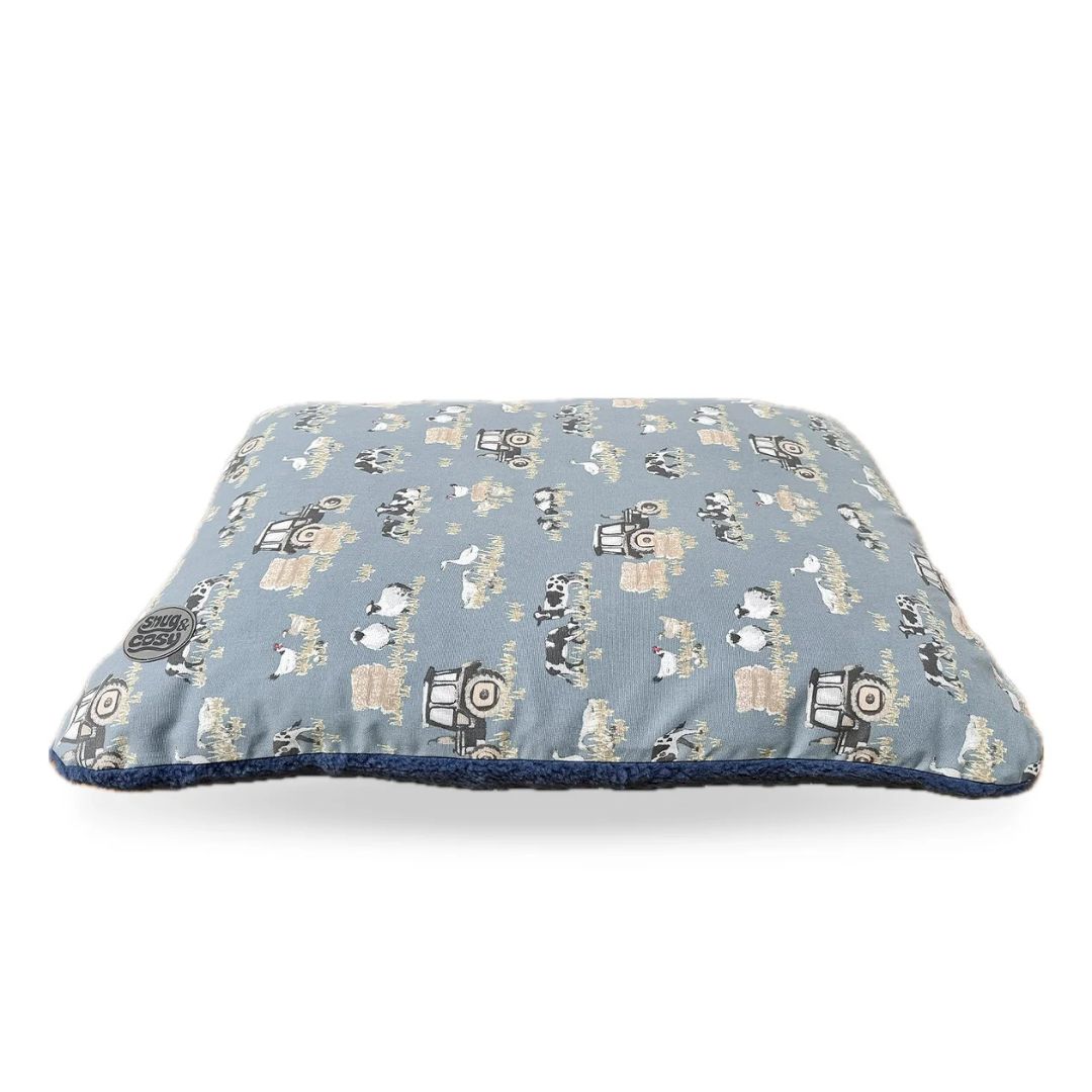 A blue dog lounger bed with a farmyard animal pattern.