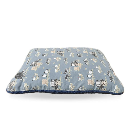 A blue dog lounger bed with a farmyard animal pattern.