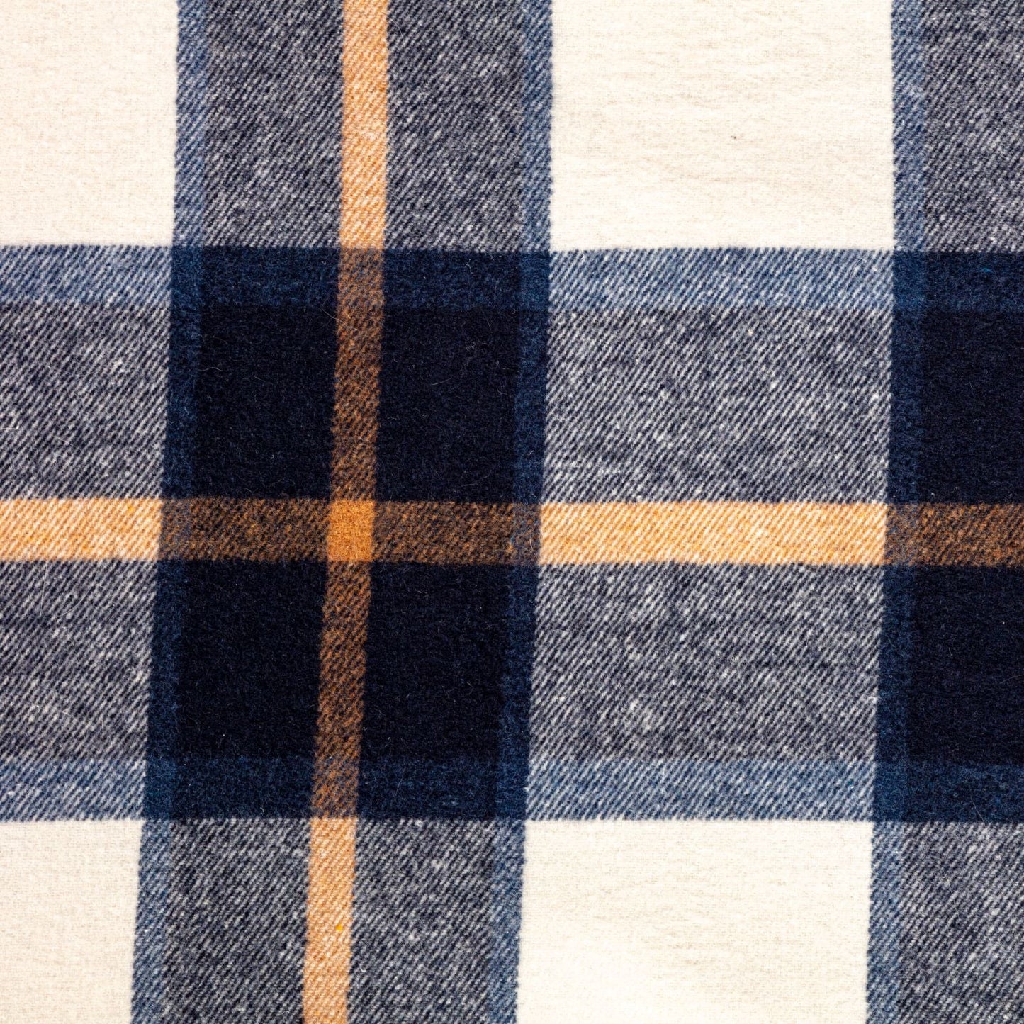 Close-up of a plaid fabric with blue, brown, and white colors.